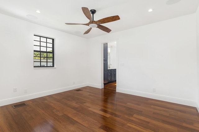 empty room featuring ceiling fan and dark hardwood / wood-style flooring