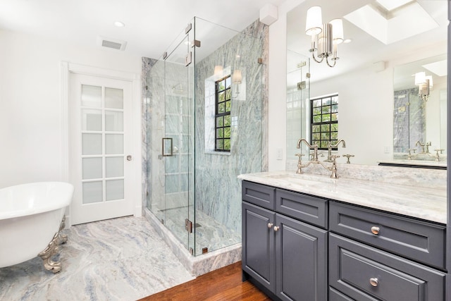 bathroom featuring a chandelier, vanity, and separate shower and tub