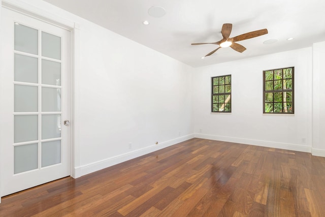 spare room featuring dark wood-type flooring and ceiling fan