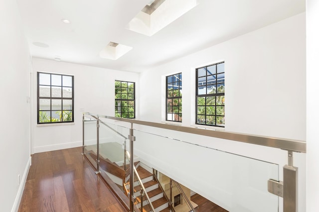 hallway featuring dark wood-type flooring and a skylight