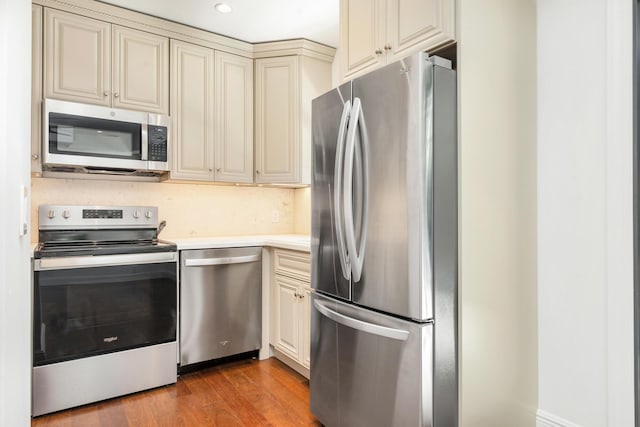 kitchen with light hardwood / wood-style flooring, cream cabinetry, and appliances with stainless steel finishes