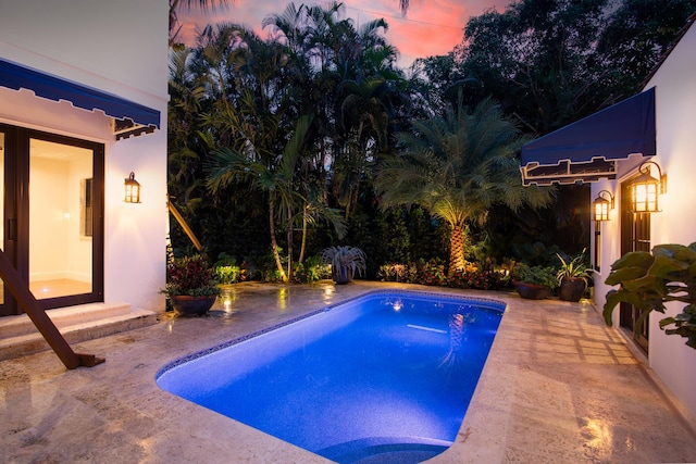 pool at dusk with a patio