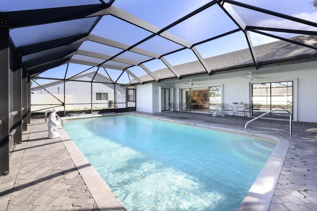 view of pool featuring glass enclosure, ceiling fan, and a patio area