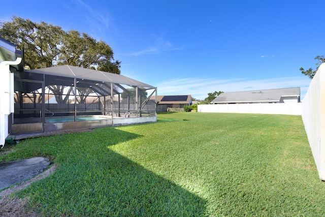 view of yard with glass enclosure and a fenced in pool