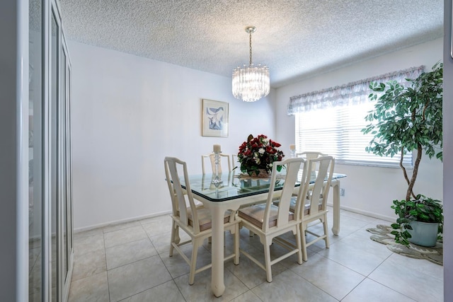 dining area with light tile patterned floors, a chandelier, and a textured ceiling