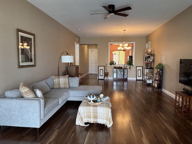 living room featuring dark hardwood / wood-style flooring and ceiling fan with notable chandelier