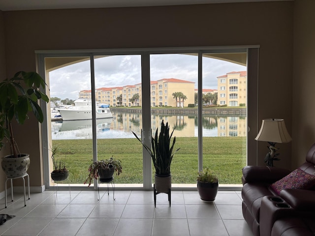 doorway to outside featuring a water view, a healthy amount of sunlight, and light tile patterned floors