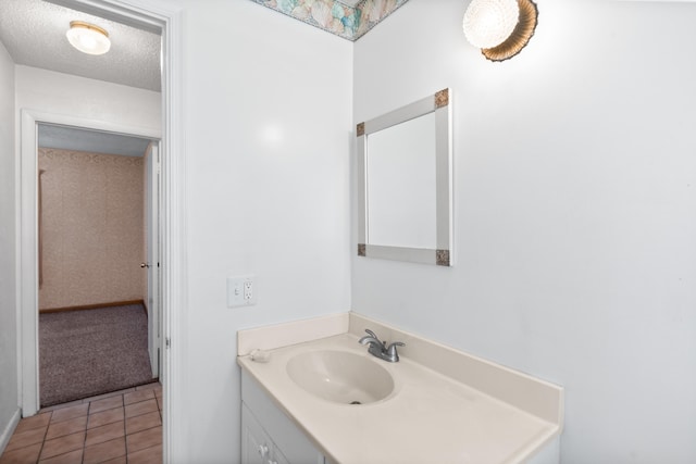 bathroom with a textured ceiling, tile patterned floors, and vanity