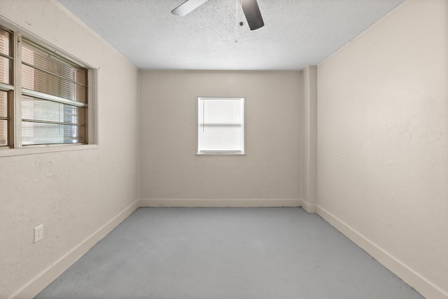 empty room with ceiling fan and a textured ceiling