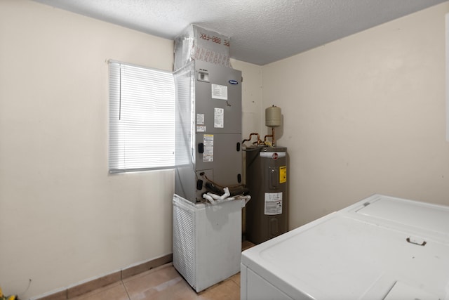 laundry area with washer and dryer, a textured ceiling, electric water heater, light tile patterned floors, and heating unit