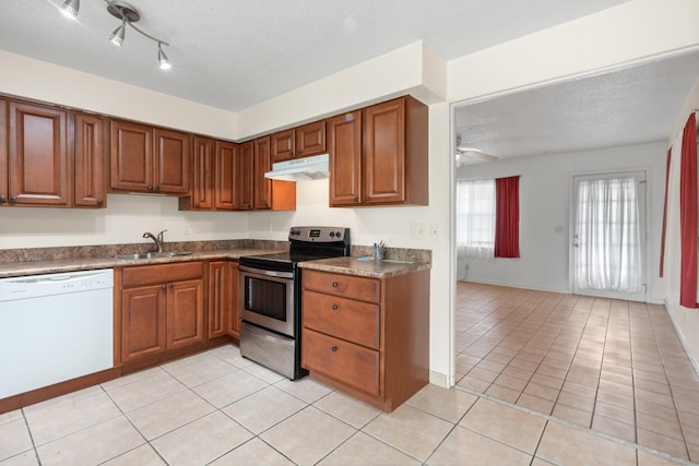 kitchen featuring a textured ceiling, sink, white dishwasher, electric range, and light tile patterned floors