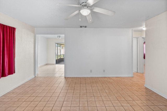 tiled empty room with ceiling fan and a textured ceiling