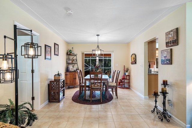 tiled dining room featuring an inviting chandelier and a textured ceiling