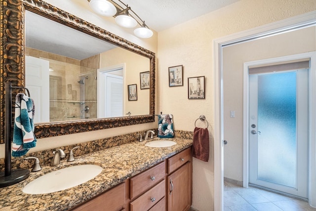 bathroom with tile patterned flooring, vanity, a textured ceiling, and a shower with shower door