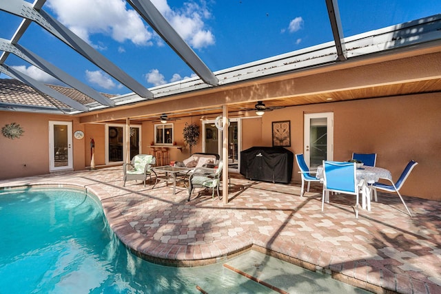 view of swimming pool featuring a patio, a lanai, and ceiling fan