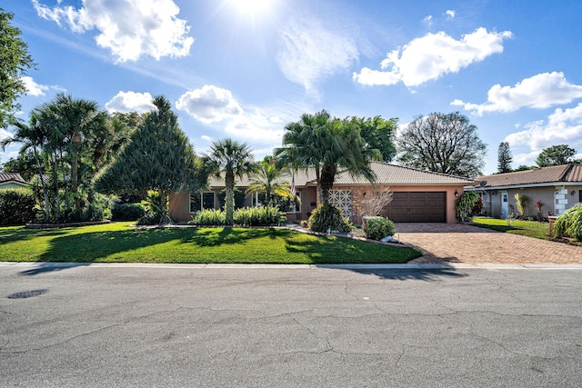 single story home with a garage and a front lawn