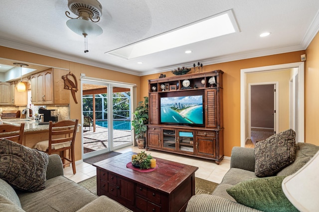 tiled living room with crown molding, sink, ceiling fan, and a skylight