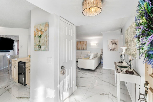 hall featuring ornamental molding, wine cooler, and an inviting chandelier