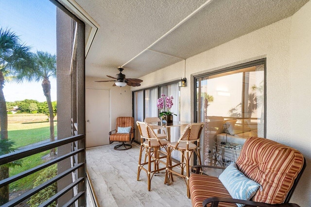 sunroom featuring a wealth of natural light and ceiling fan