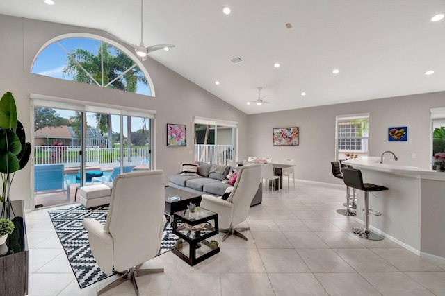 tiled living room with high vaulted ceiling, ceiling fan, and sink