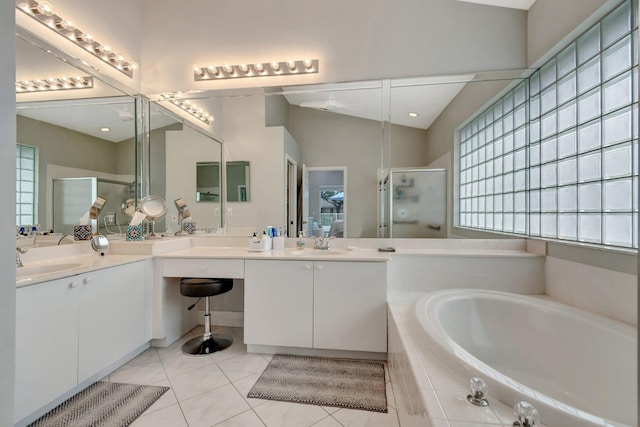 bathroom featuring tile patterned floors, vanity, independent shower and bath, and vaulted ceiling