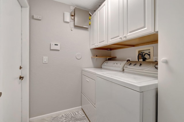 laundry room featuring cabinets, washing machine and dryer, and light tile patterned floors