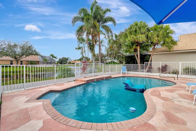 view of swimming pool featuring a patio and a water view