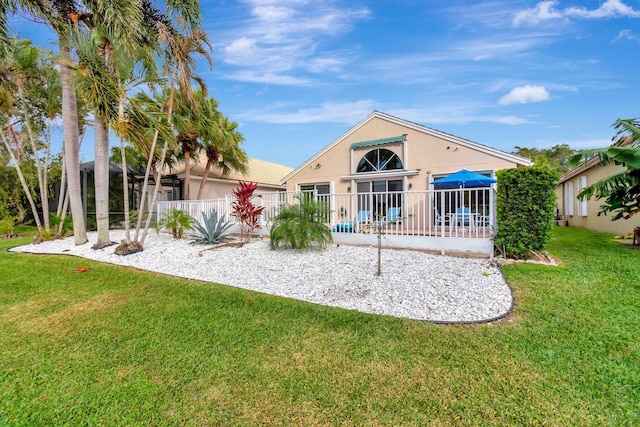 rear view of property featuring a lawn