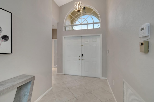 entryway with light tile patterned flooring and a high ceiling