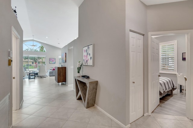 hall with light tile patterned flooring and vaulted ceiling