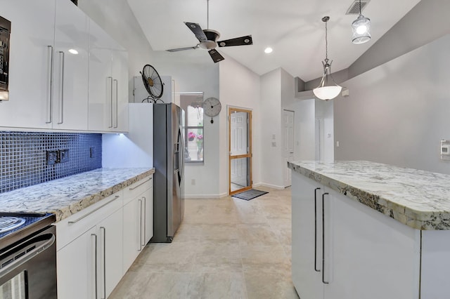 kitchen with pendant lighting, white cabinetry, backsplash, and vaulted ceiling