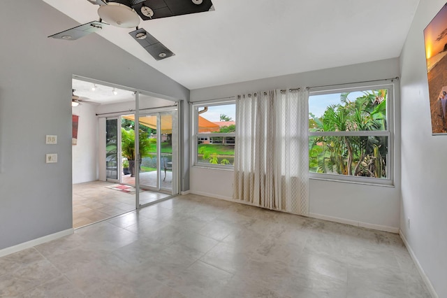 spare room featuring ceiling fan, a healthy amount of sunlight, and vaulted ceiling