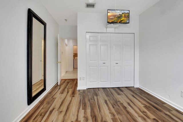 unfurnished bedroom featuring hardwood / wood-style flooring and a closet