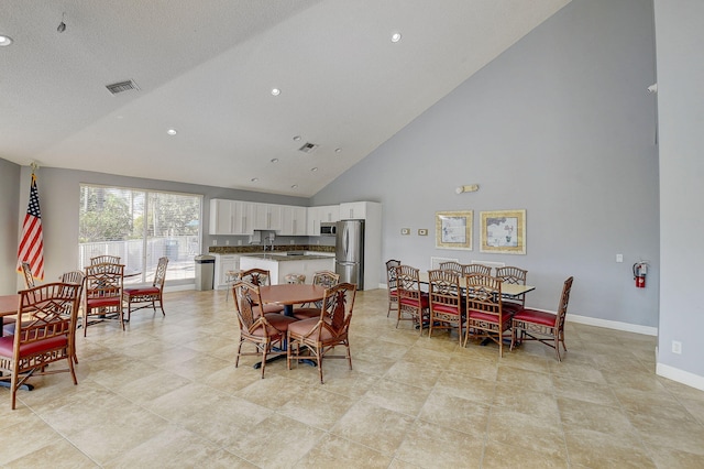 dining area with high vaulted ceiling