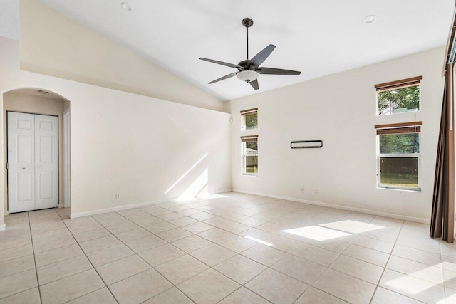 tiled empty room with ceiling fan and lofted ceiling