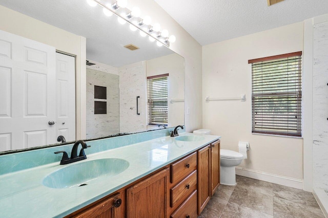 bathroom featuring vanity, toilet, and a textured ceiling