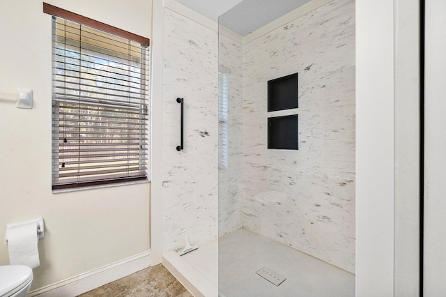 bathroom with toilet and a tile shower