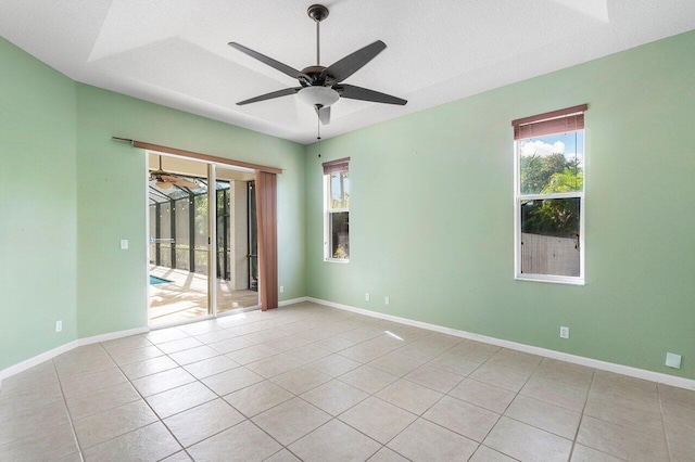 tiled spare room with a textured ceiling, plenty of natural light, and ceiling fan