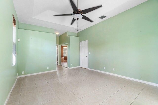 empty room with ceiling fan, light tile patterned floors, and a textured ceiling