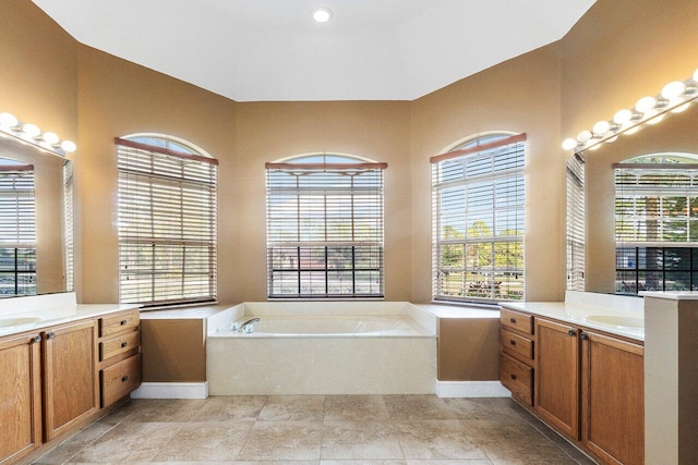 bathroom with vanity, a tub to relax in, and a healthy amount of sunlight