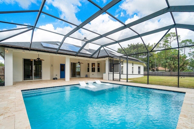 view of pool with a lanai, ceiling fan, a yard, and a patio