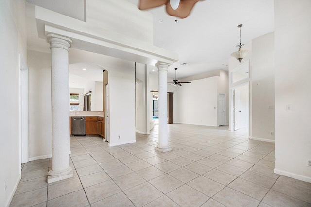 unfurnished living room featuring decorative columns, ceiling fan, a towering ceiling, and light tile patterned floors