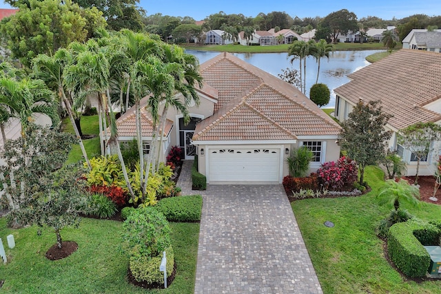 view of front of home featuring a front yard, a garage, and a water view