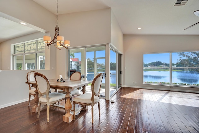 dining space with a water view, dark hardwood / wood-style floors, and an inviting chandelier