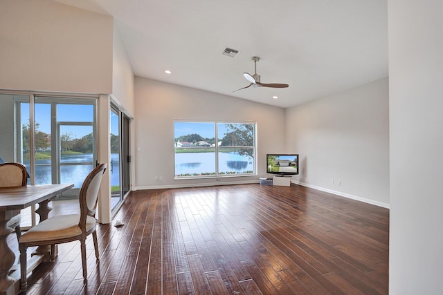 unfurnished living room featuring dark hardwood / wood-style flooring, a water view, plenty of natural light, and ceiling fan