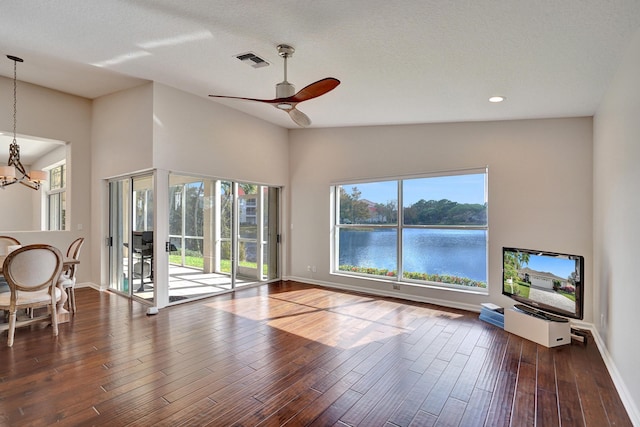 unfurnished living room featuring a textured ceiling, dark hardwood / wood-style floors, ceiling fan, and lofted ceiling