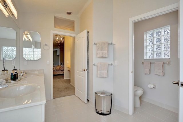 bathroom with tile patterned flooring, vanity, toilet, and lofted ceiling