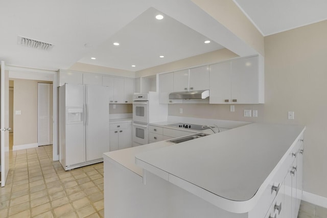 kitchen featuring kitchen peninsula, sink, white cabinets, and white appliances