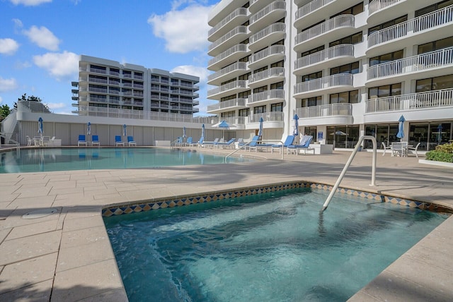 view of swimming pool featuring a community hot tub and a patio