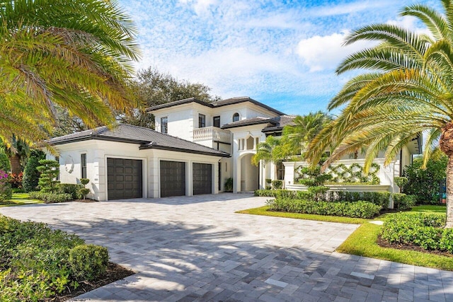 mediterranean / spanish-style home with an attached garage, decorative driveway, and stucco siding